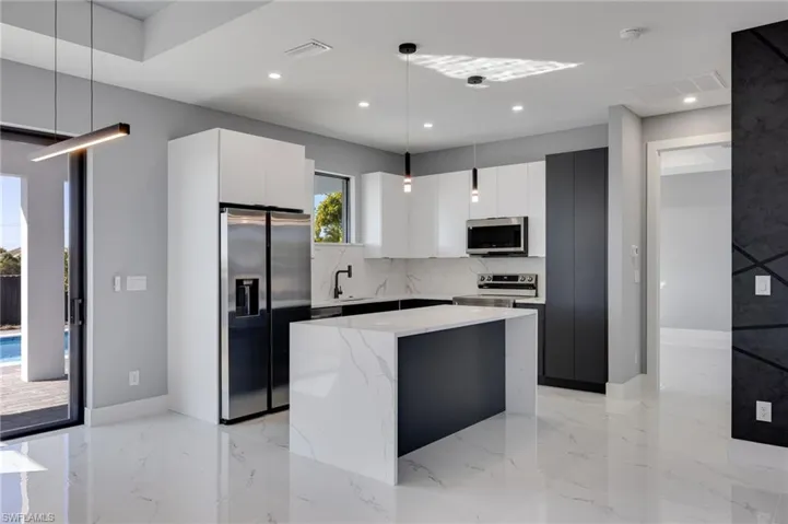 Kitchen featuring pendant lighting, stainless steel appliances, modern cabinets, and a kitchen island