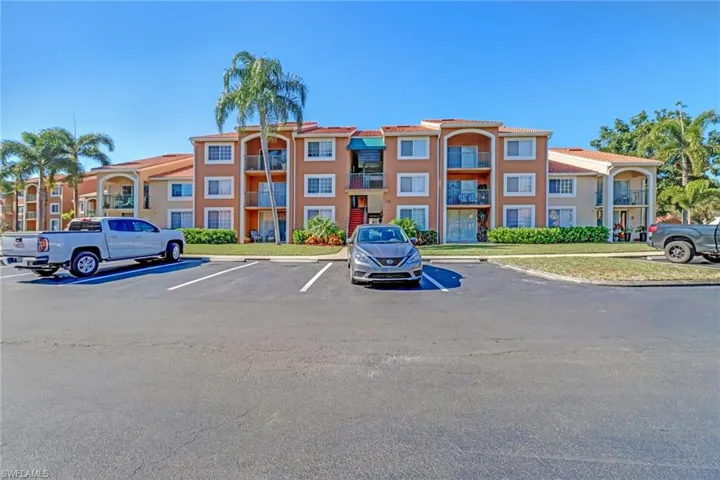 View of apartment building / complex with uncovered parking