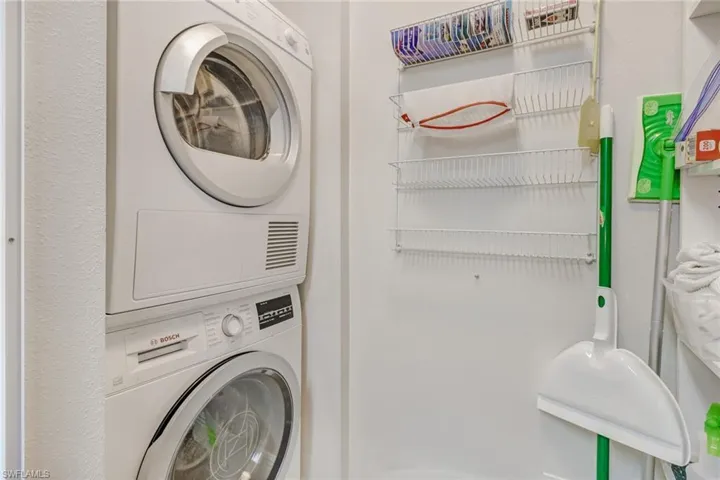 Laundry area featuring stacked washing machine and dryer