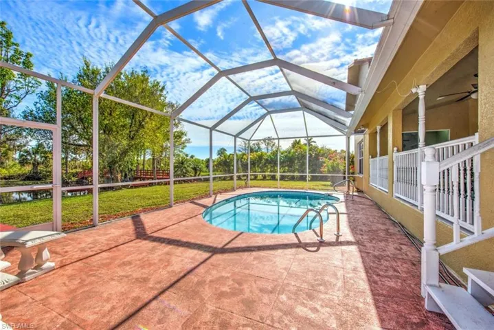 Swimming pool featuring a patio, glass enclosure, a sunroom, and a lawn