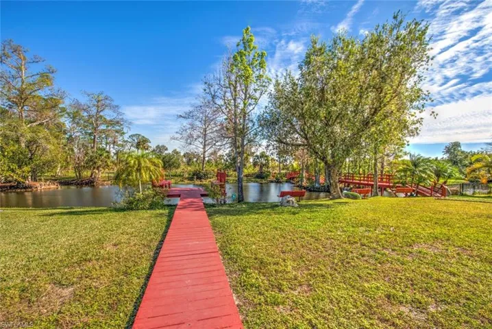 Dock area with a yard and a water view