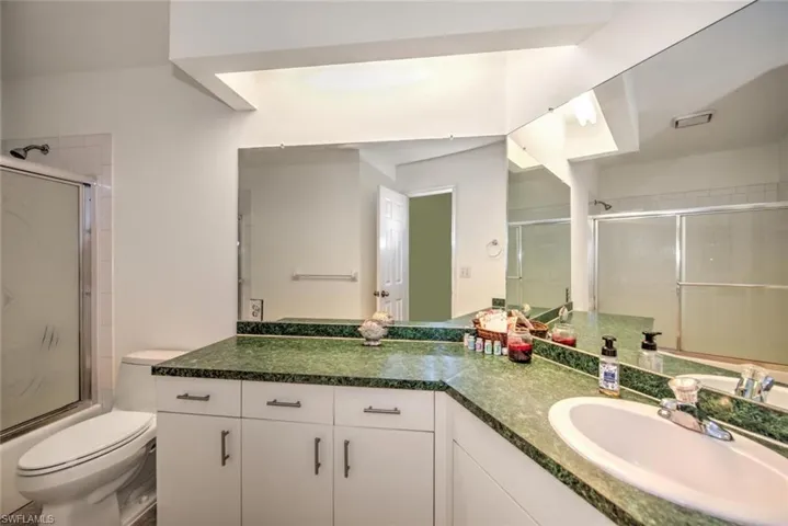 Full bath with vanity and bath / shower combo with glass door