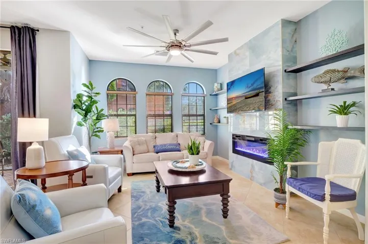 Tiled living room featuring ceiling fan and fireplace