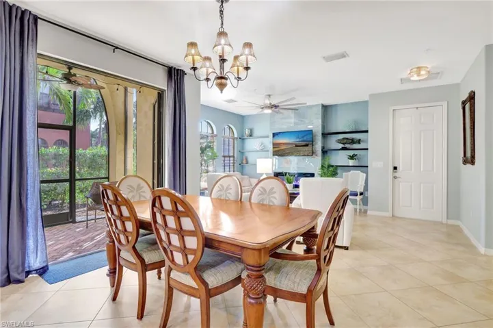 Tiled dining space featuring plenty of natural light and  chandelier