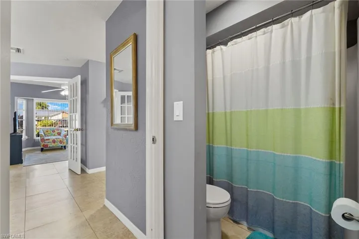 Bathroom featuring ceiling fan, tile patterned flooring, and toilet