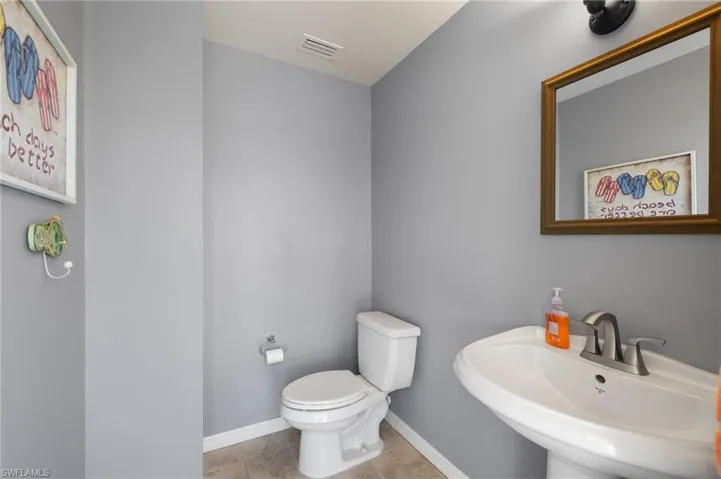 Bathroom featuring tile patterned flooring, toilet, and sink