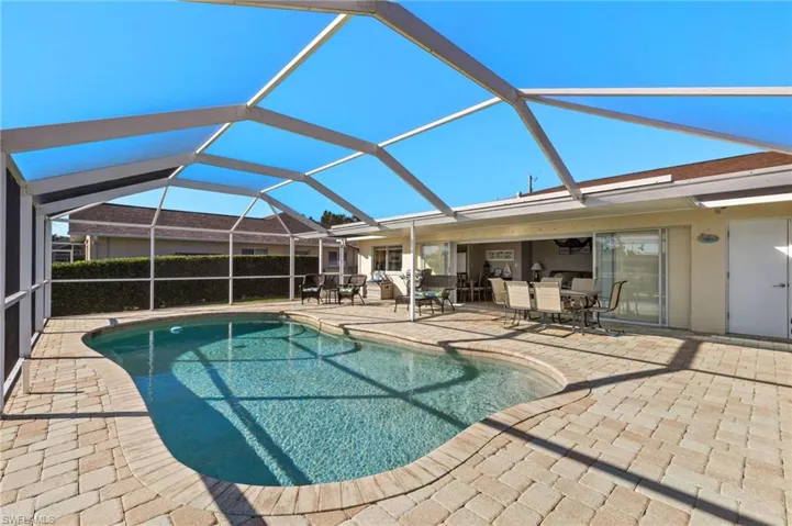 View of pool with a patio and glass enclosure