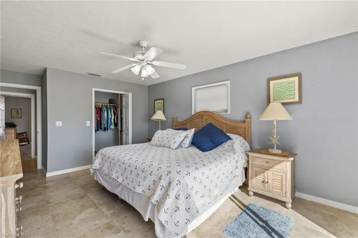 Bedroom with a textured ceiling, a closet, a spacious closet, and ceiling fan