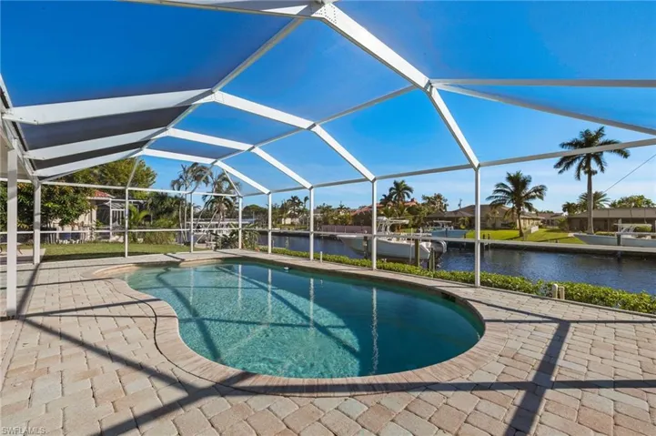 View of swimming pool featuring a lanai, a patio area, and a water view