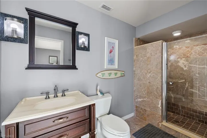 Bathroom with tile patterned floors, vanity, toilet, and walk in shower
