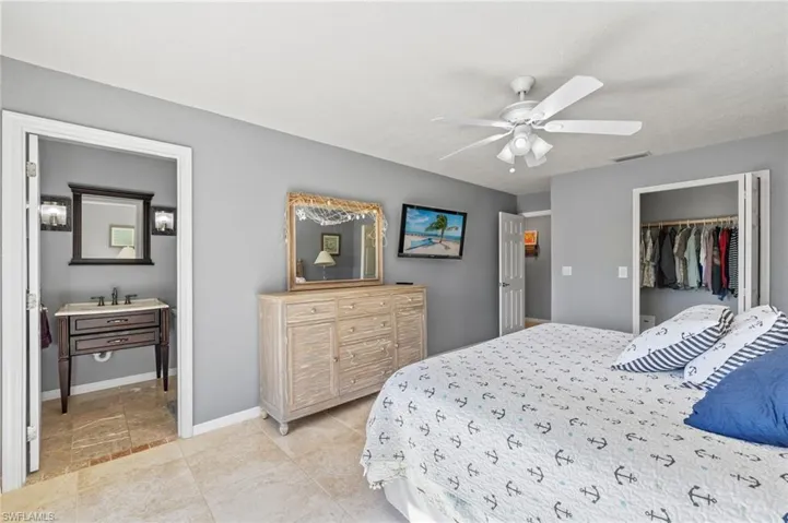 Bedroom featuring ceiling fan, sink, and a closet