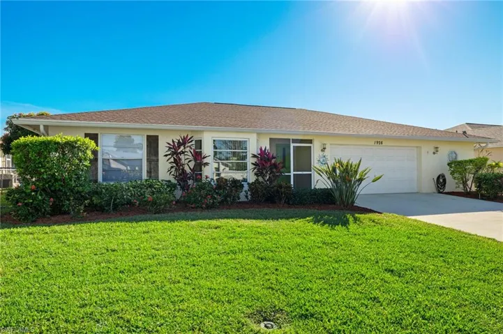 Ranch-style home with a garage and a front lawn