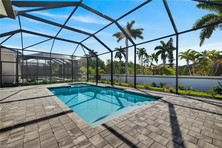 Relaxing pool / spa featuring a sunroom, a lanai, and a patio area