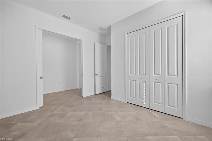 Den featuring baseboards and a closet