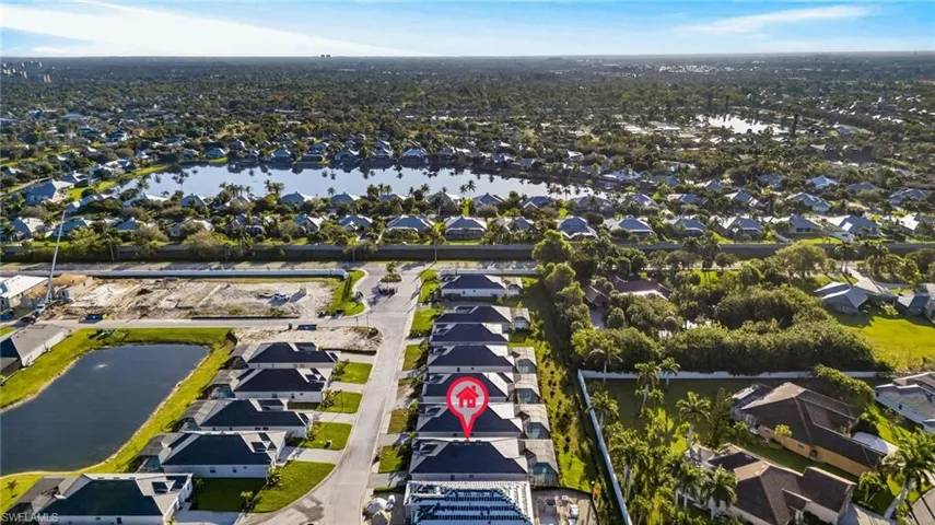 Aerial overview of property's location featuring a nearby body of water and nearby suburban area