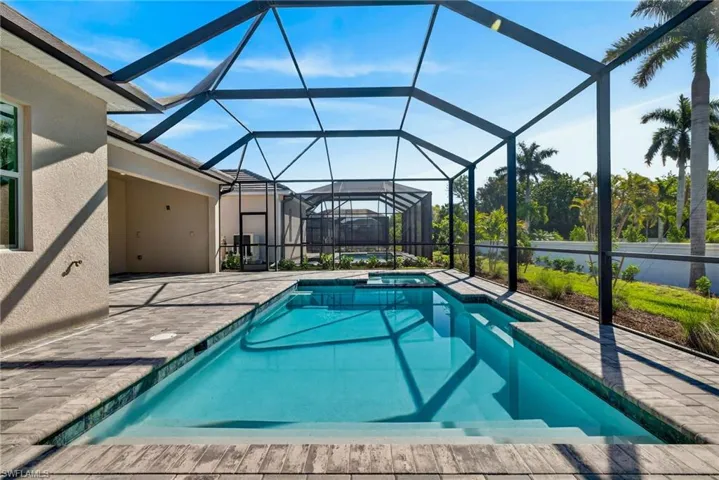 Relaxing pool / spa with a sunroom, a patio, and glass enclosure