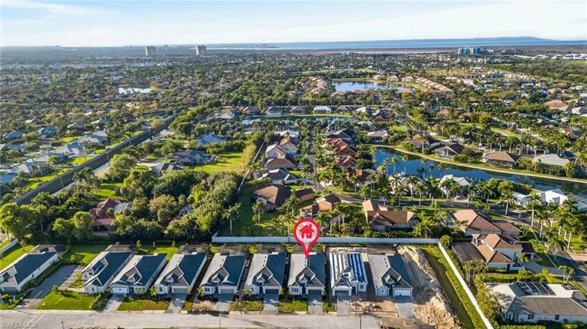 Aerial view of property and surrounding area featuring a large body of water and nearby suburban area