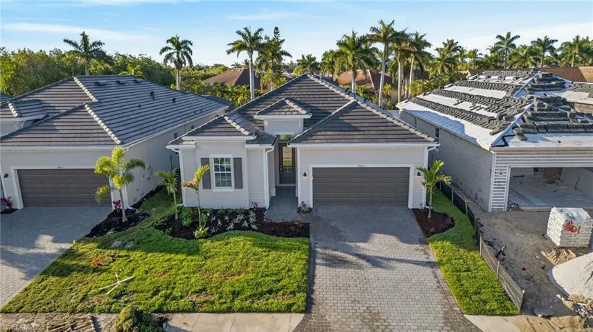 View of front of house with a garage, decorative driveway, and a tiled roof