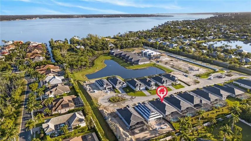 Aerial perspective of suburban area featuring a nearby body of water