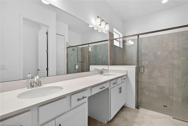 Primary Bathroom with double vanity and a stall shower