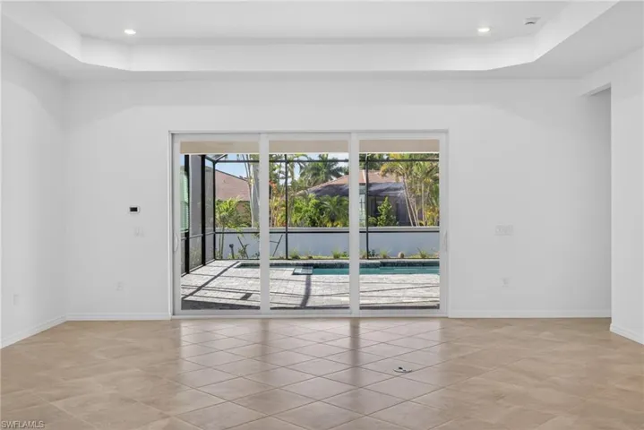 Family room with a tray ceiling, light tile patterned flooring, and recessed lighting