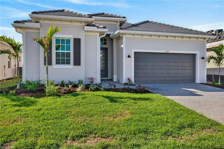 View of front facade featuring decorative driveway, a front lawn, and a garage