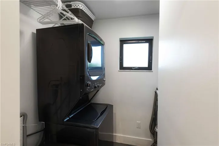 Clothes washing area featuring stacked washer and dryer