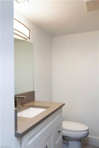Bathroom with vanity, toilet, and tile patterned flooring