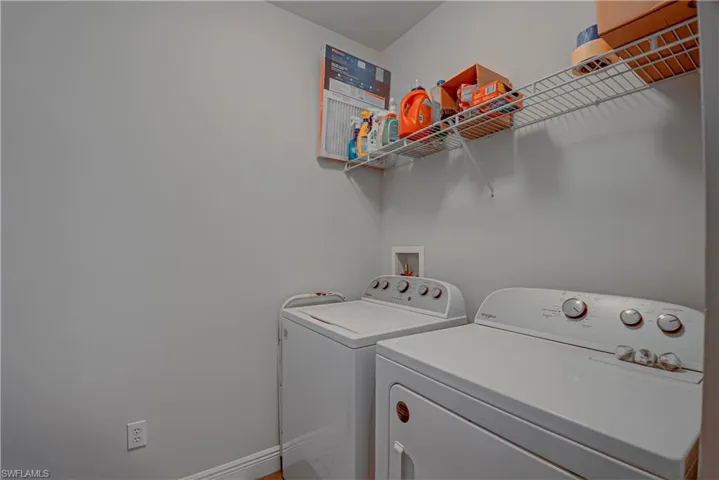 Washroom featuring baseboards and independent washer and dryer
