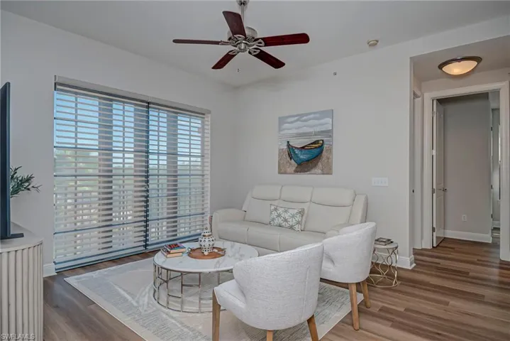 Living area featuring new floors and a ceiling fan