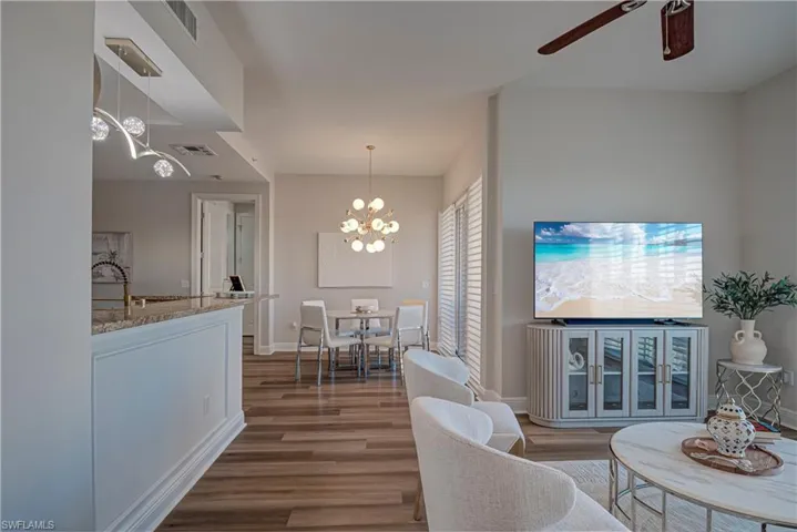Living room featuring wood finished floors, a chandelier, and a ceiling fan