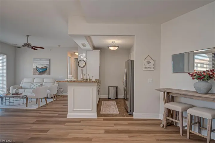 Kitchen featuring open floor plan, light wood-style floors, a peninsula, and freestanding refrigerator