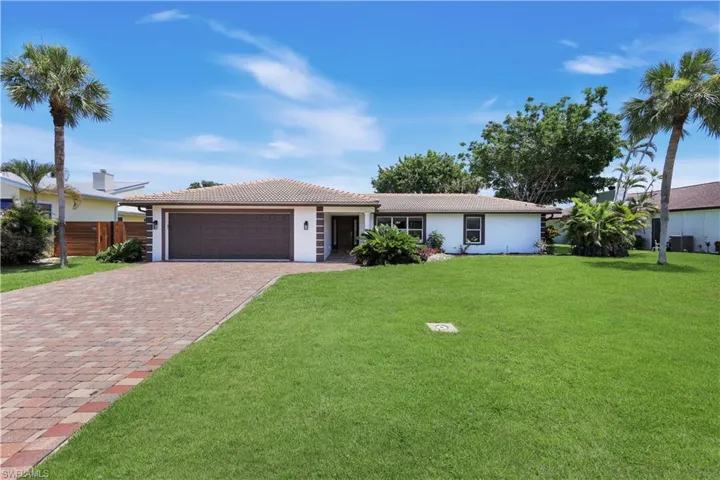Exterior with fresh paint, a two-car garage, front yard and a paver driveway.