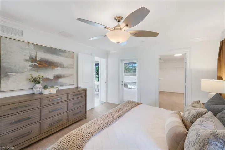 Primary bedroom with large walk-in closet, crown molding, carpet and en-suite bathroom access (not shown).