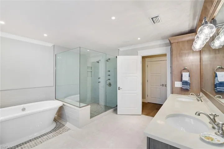 Bathroom featuring tile patterned flooring, vanity, separate shower and tub, and ornamental molding