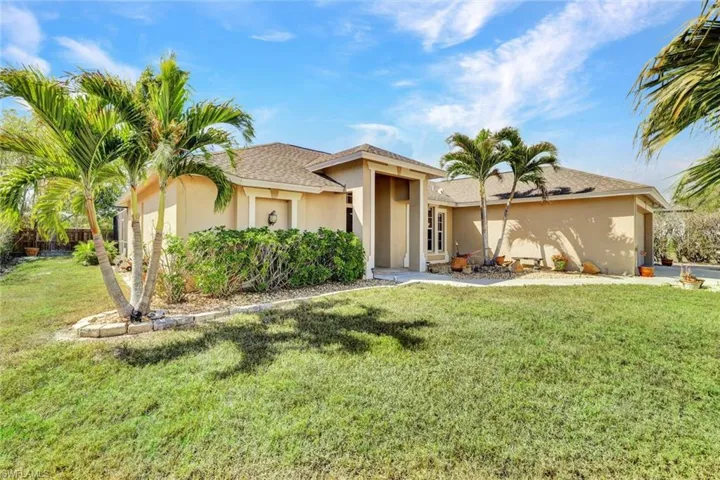 Single story home with stucco siding, a front lawn, and a shingled roof