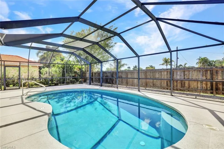 Screened lanai with pool and privacy behind.