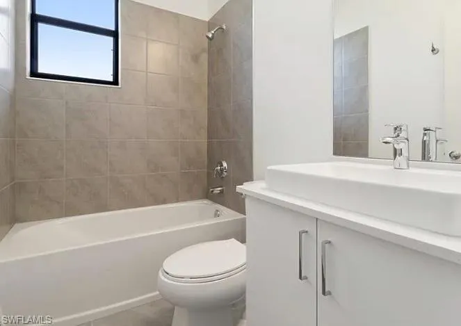 Bathroom featuring a white bathtub, tiled shower surround, and a rectangular window