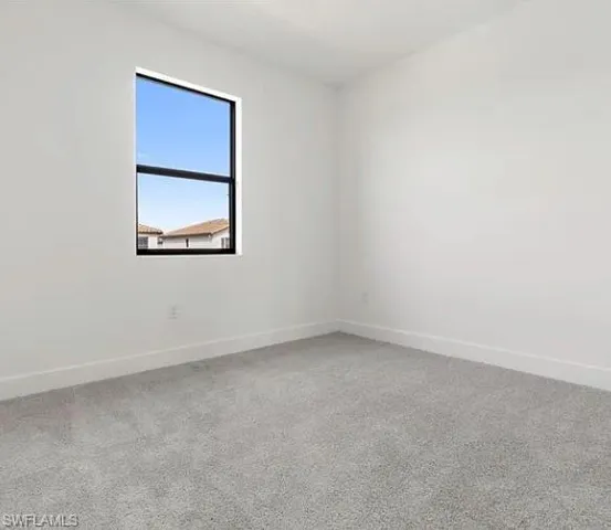 Bright room featuring a single window with a black frame and a neutral color palette