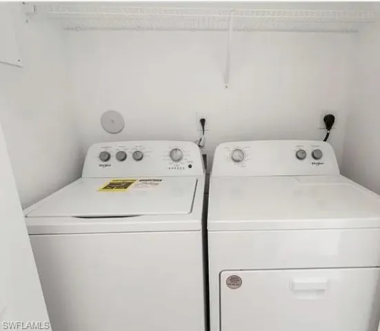 Dedicated laundry space featuring a white top-load washing machine and front-load dryer