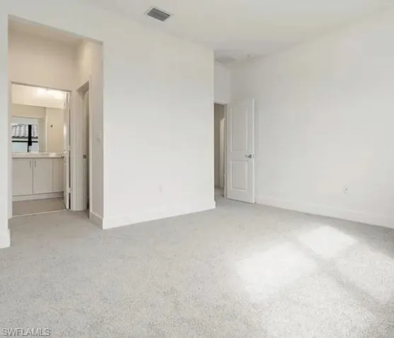 Bright room featuring light gray carpeting and white walls