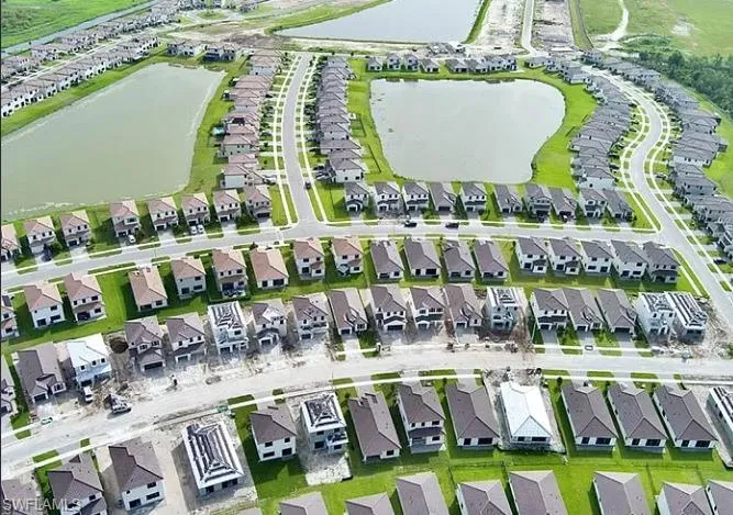 Extensive residential development featuring numerous single-family homes, multiple ponds, paved roads, and manicured lawns