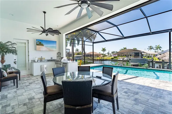 View of pool featuring a patio area, area for grilling, and ceiling fans.