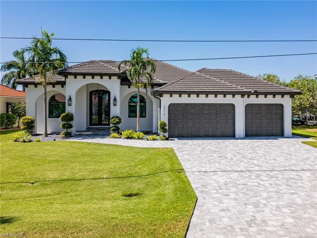 View of front facade featuring an oversized 3 car garage and a front yard