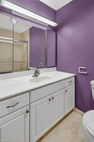 Bathroom with a shower stall, vanity, and light tile patterned floors