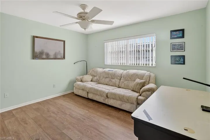 Furniture has been removed, wood finished floors and ceiling fan