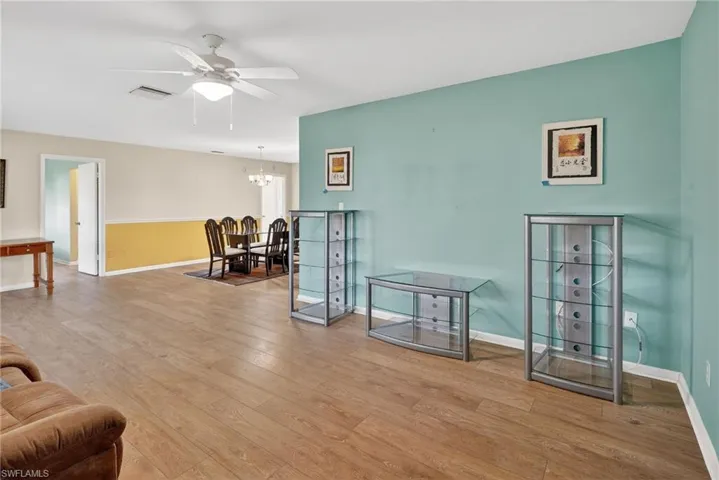 Living area featuring hardwood / wood-style floors, a ceiling fan, and a chandelier