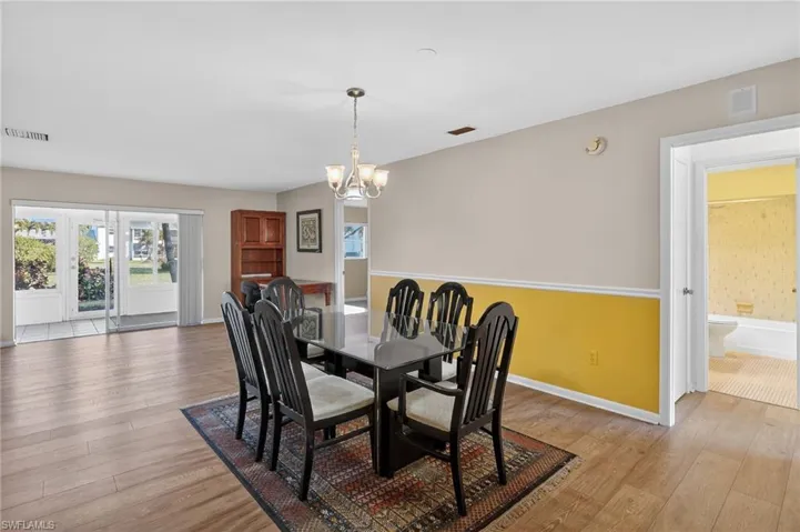 Dining area with light wood-style flooring and a chandelier