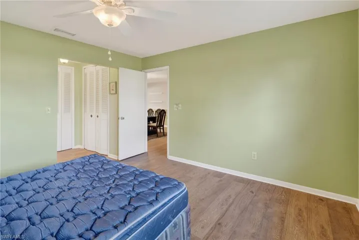 Bedroom with wood finished floors, a ceiling fan, and a closet