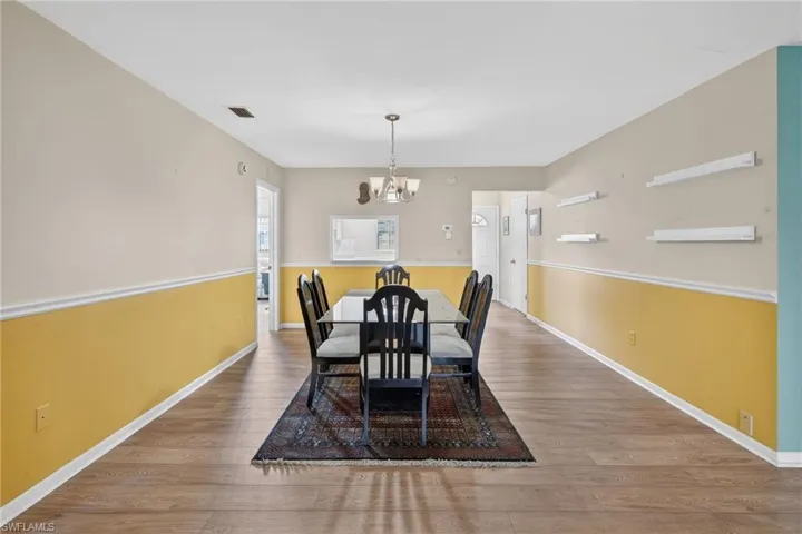 Dining area with wood finished floors and a chandelier
